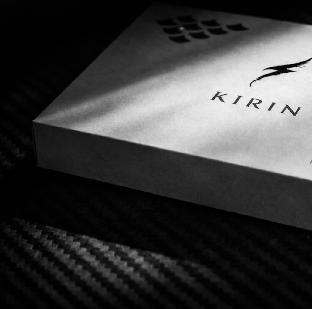Luxury Kirin Scent 01 packaging on a supercar's carbon fiber surface. The best high-end car fragrance gift for automotive enthusiasts and supercar owners.